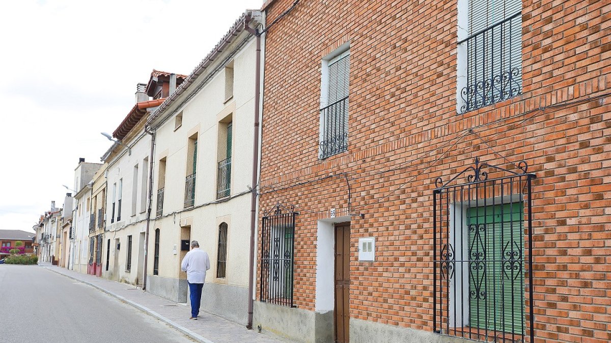 Un vecino de Valoria la Buena camina por una calle de la localidad, incluida en el estudio que realizarán los API sobre viviendas vacías en la provincia. J.M. LOSTAU