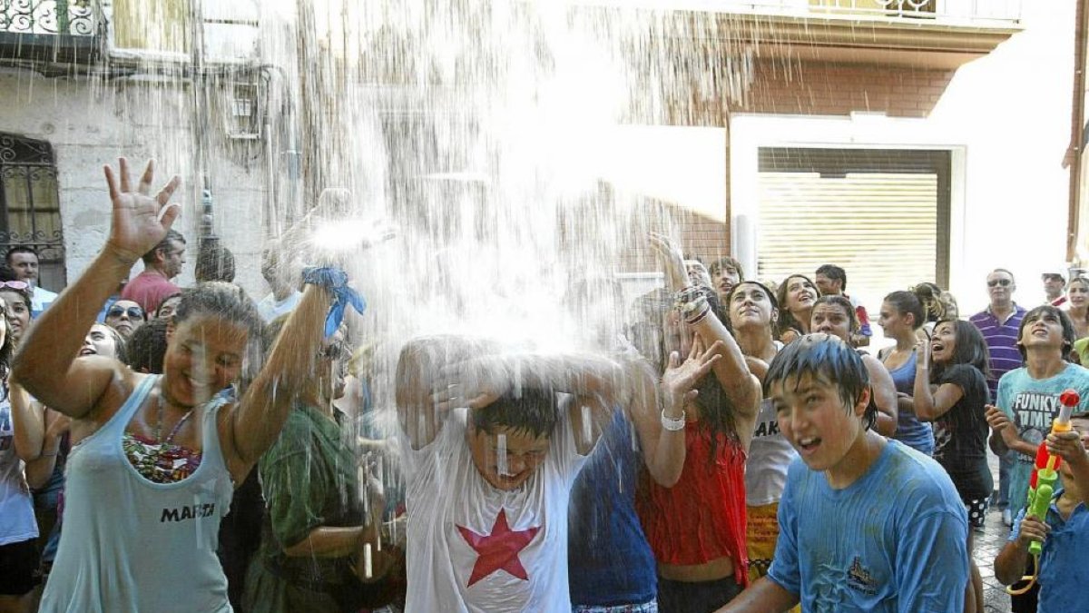 Varios jóvenes reciben un calderazo de agua durante el Chúndara de Peñafiel.-ALBERTO MINGUEZA