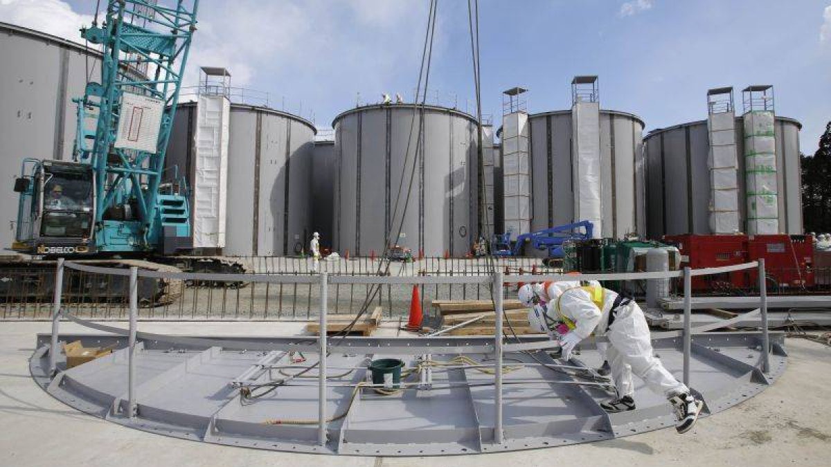 Dos operarios trabajan ante unos tanques de agua de Fukushima.-Foto: REUTERS / TORU HANAI