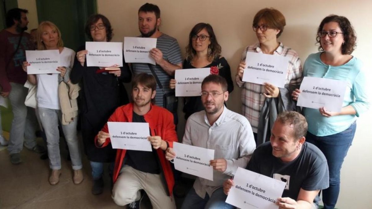 Diputados de la CUP y de Podem en Barberà del Vallès con carteles a favor de la democracia y del referéndum.-LAURA CORTÉS