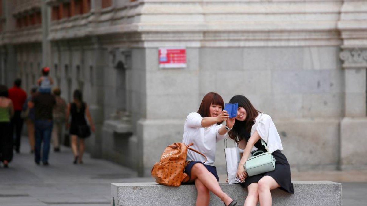 Dos turistas se fotografían en la plaza Mayor de Valladolid.-ICAL