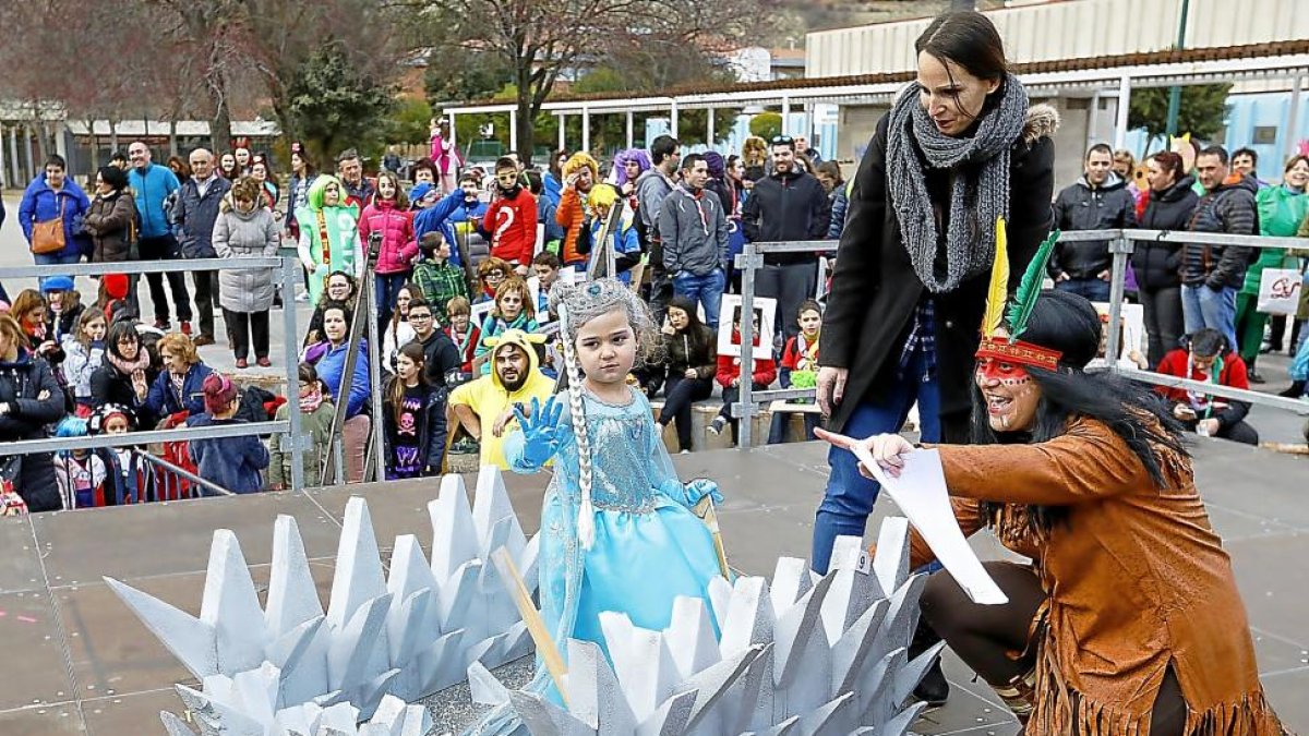 Una pequeña disfrazada de la princesa de Frozen saluda al público junto con la presentadora y su madre.-J. M. LOSTAU