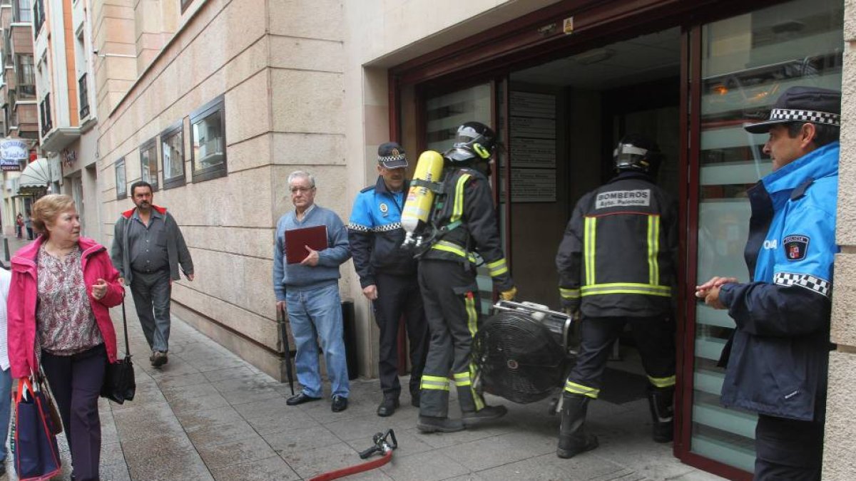 Unos bomberos introducen en la Gerencia un extractor para retirar el humo-Ical