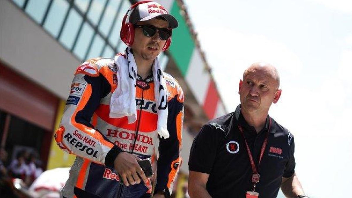 Jorge Lorenzo sale de su boxe acompañado de Quique, uno de sus ayudantes.-ALEJANDRO CERESUELA