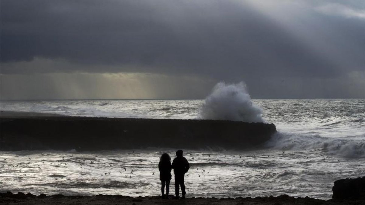 Dos marroquís frente al mar durante una inusual tormenta en Rabat, el 8 de enero.-/ AFP / FADEL SENNA