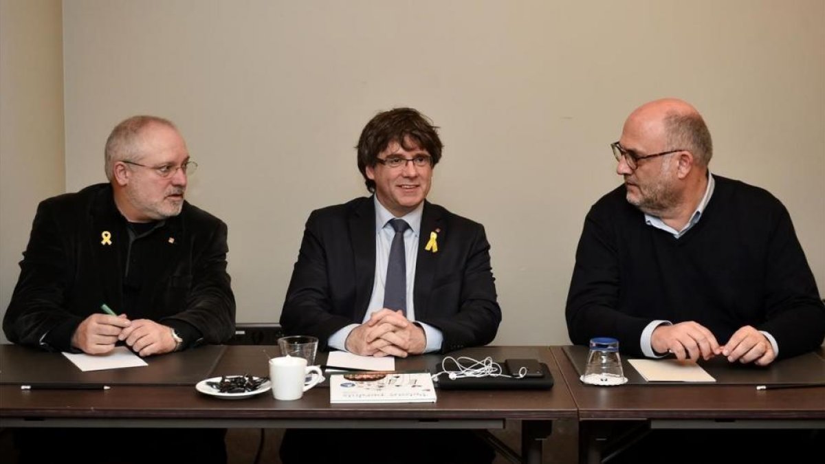 Carles Puigdemont, flanqueado por el exconseller Lluís Puig y el diputado de JxCat Eduard Pujol, este miércoles en Bruselas.-JOHN THYS (AFP)