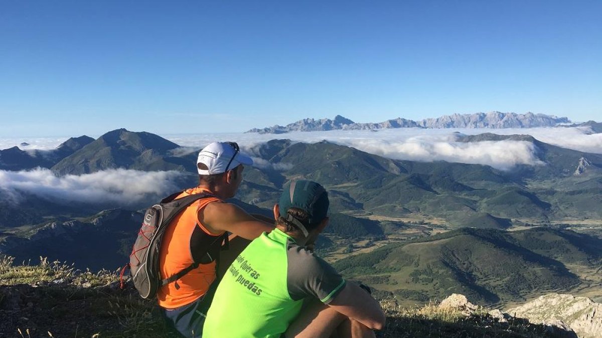Dos montañeros contemplan las cumbres de Picos de Europa desde el Valjarto.-N.S.