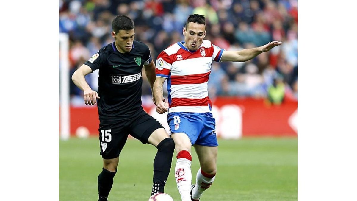 Fede San Emeterio (d) pugna por el balón en el partido Granada-Málaga de esta pasada temporada.-LALIGA