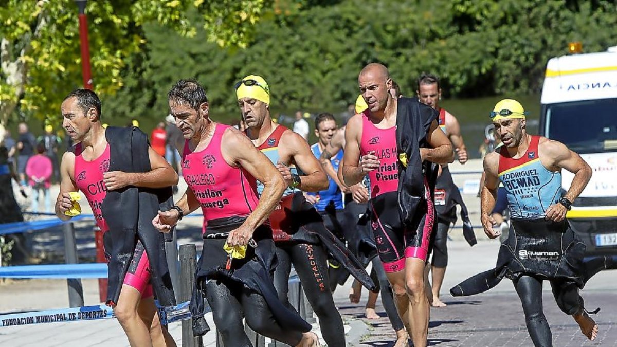 Los componentes del equipo del Tripi en la transicción de la salida del agua para comenzar la prueba ciclista.-J. M. LOSTAU