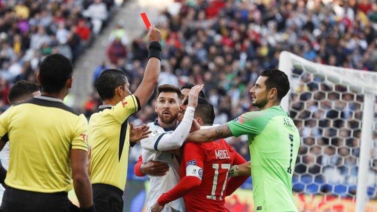 El colegiado muestra la tarjeta roja a Messi y Medel.-AP / VICTOR R. CAIVANO