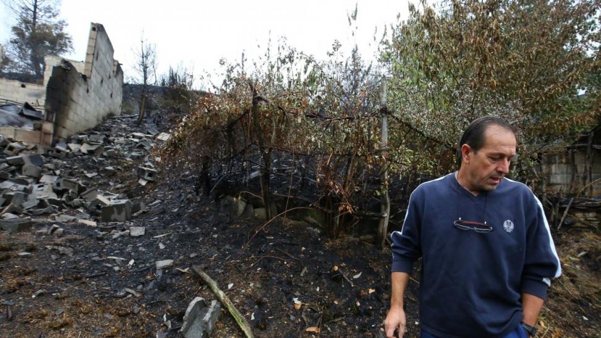El presidente de la junta vecinal de de San Pedro de Paralela (León), perteneciente al municipio de Fabero, Manolo Ruíz, junto a su nave totalmente calcinada en el fuego de ayer-ICAL