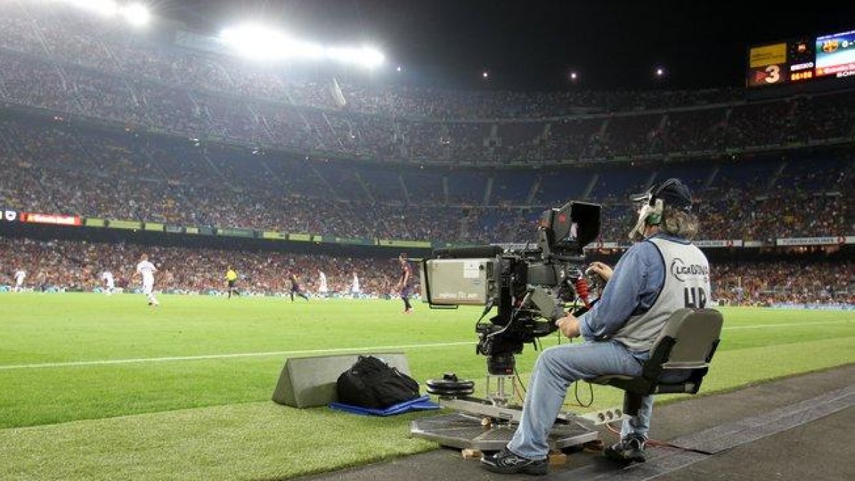 Un reportero gráfico grabando un partido de fútbol.-