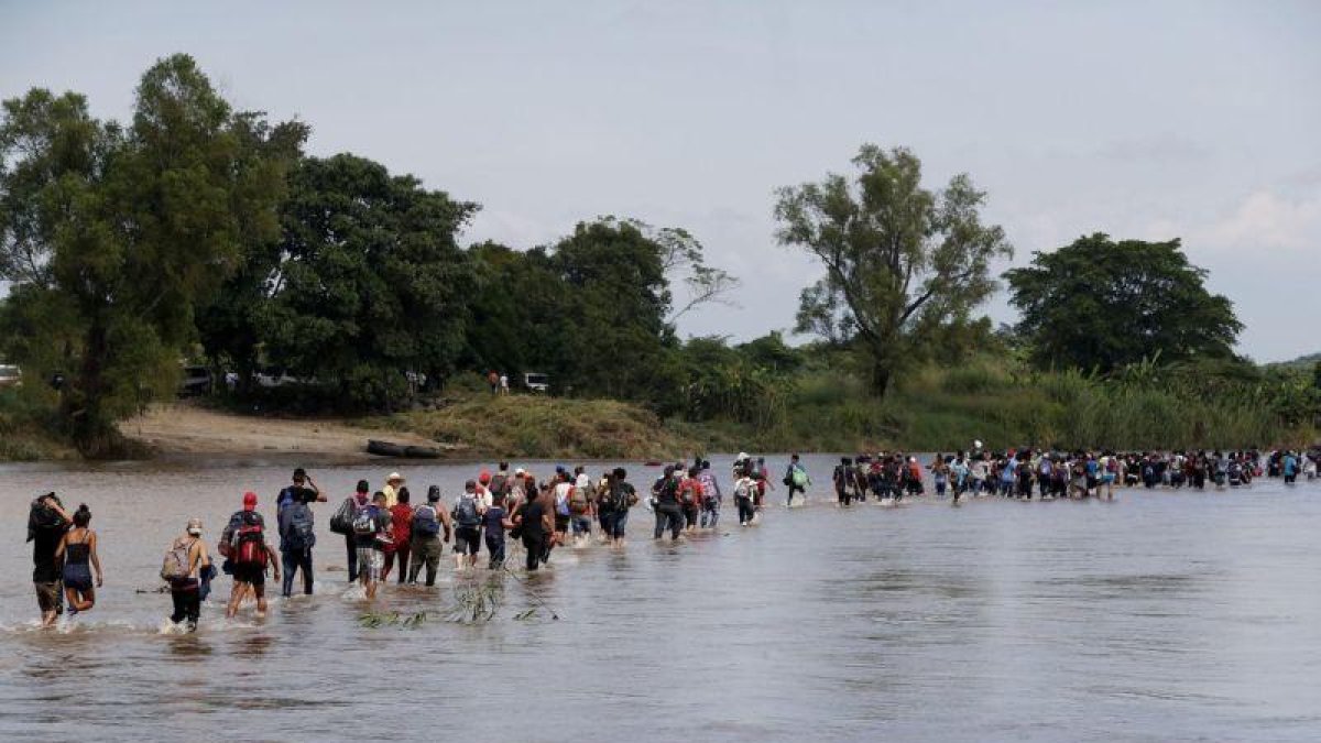 Integrantes de la segunda caravana de migrantes  en su mayoria hondurenos  cruzan a pie el rio Suchiate.-EFE
