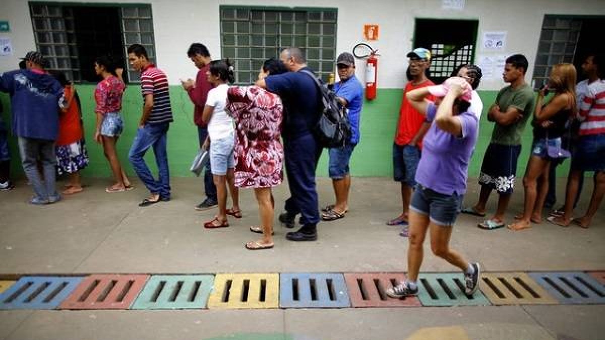 Un grupo de personas forma una fila en un puesto de votación en la favela Estrutural, en Brasilia, durante la segunda vuelta de las elecciones presidenciales.-EFE /Foto: FERNANDO BIZERRA JR.