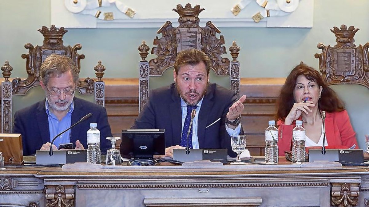 Manuel Saravia mira su móvil mientras Óscar Puente se dirige a los concejales durante la celebraciónel pleno municipal.-J. M. LOSTAU