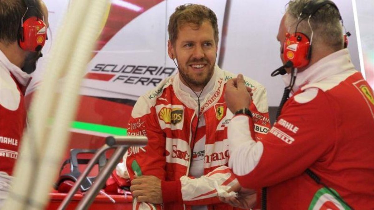 Sebastian Vettel dialoga con miembros del equipo Ferrari, en México.-ULISES RUIZ BASURTO