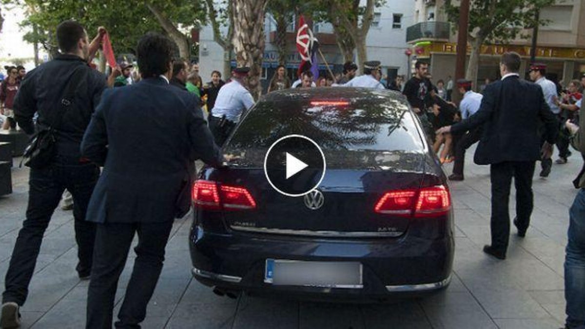 Manifestantes lanzan objetos y golpean con un palo el coche oficial de Montoro en un acto en Vilanova. /-YOUTUBE
