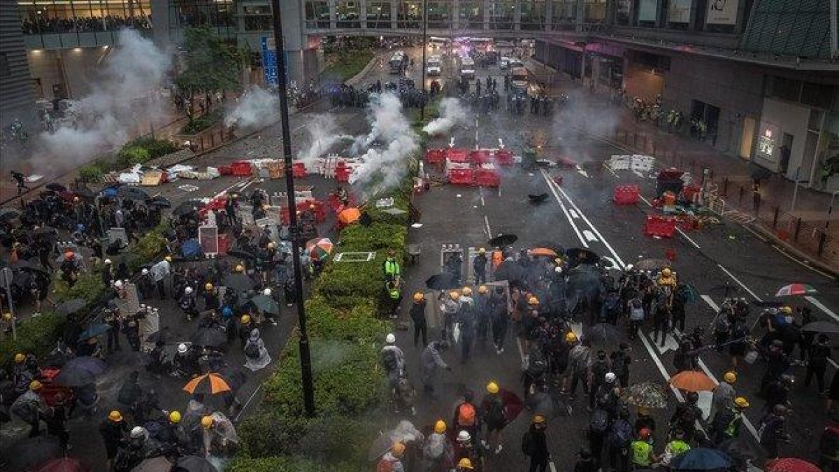 Enfrentamientos entre manifestantes y policías en Hong Kong, este domingo.-EFE EPA / ROMAN PILIPEY