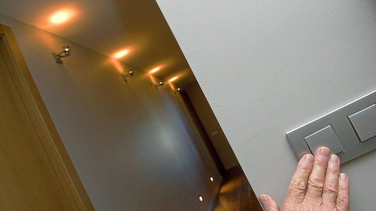 Una persona apaga las luces del pasillo de su casa.-EL MUNDO