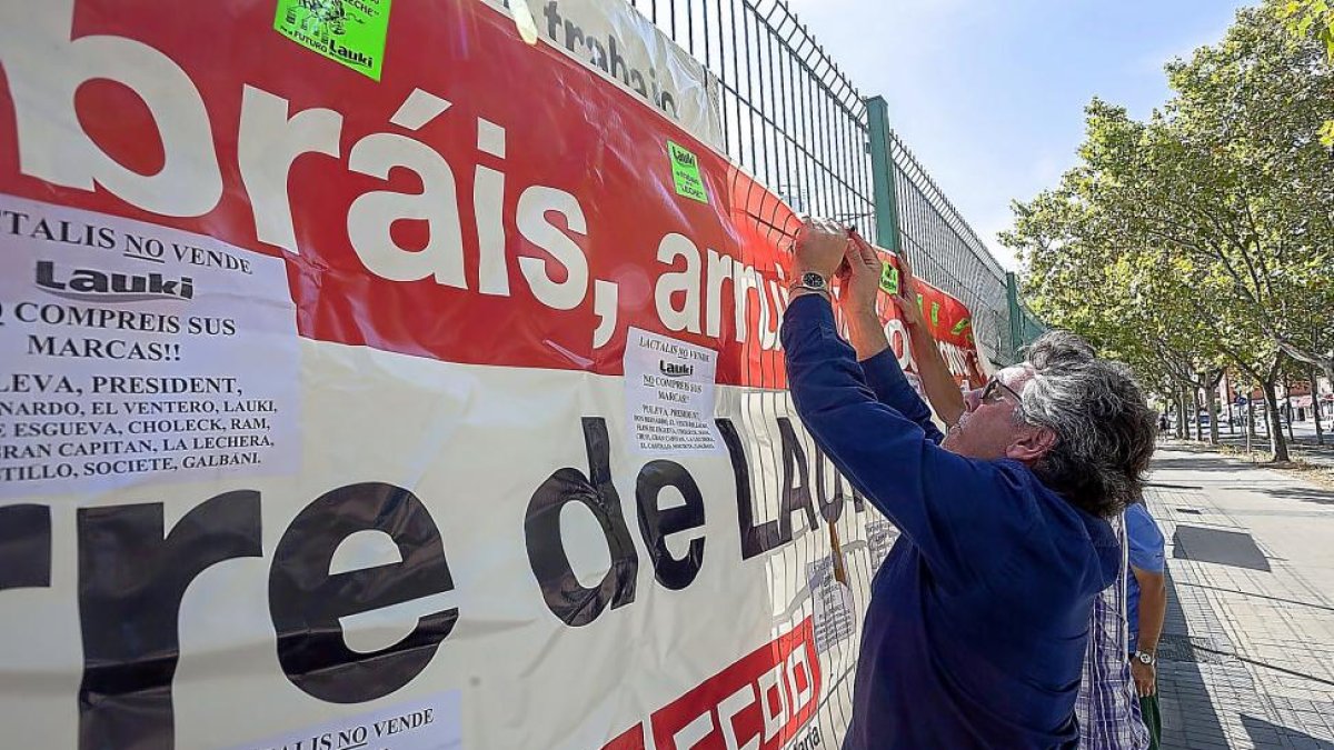 Los trabajadores de Lauki cuelgan carteles durante las protestas por el cierre.-PABLO REQUEJO