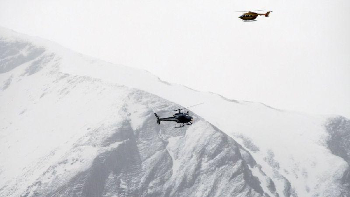 Dos helicópteros patrullan sobre los Alpes franceses durante un rescate.-AP