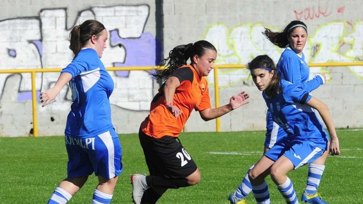 Carolina Birizamberri se lleva el balón ante la presencia de dos jugadoras del UBU.-ISRAEL L. MURILLO