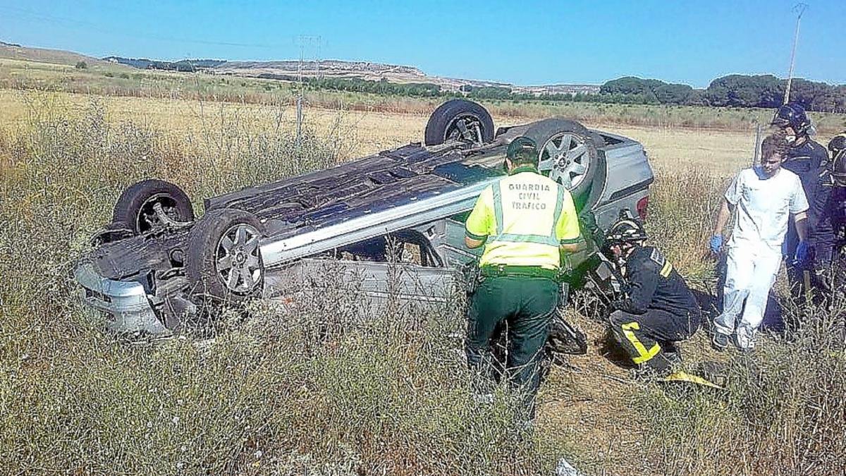 Policía, bomberos y personal sanitario junto al vehículo volcado a la altura de Tordesillas.-ICAL