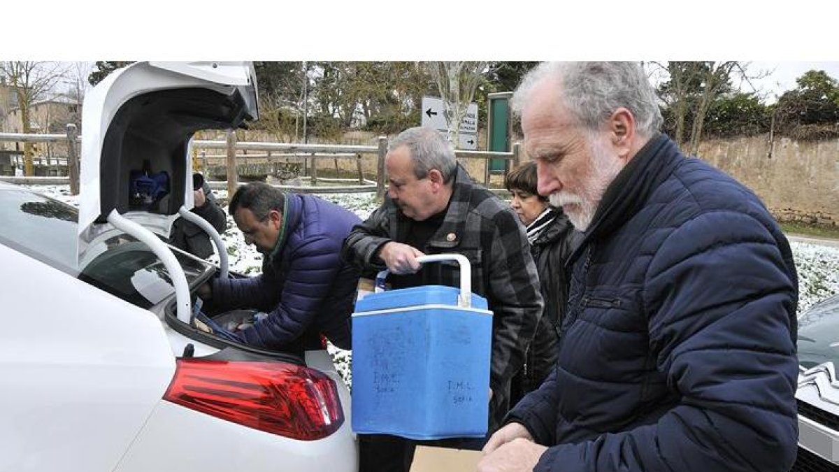 Un empleado del centro forense mete una de las neveras con restos en un coche-VALENTÍN GUISANDE