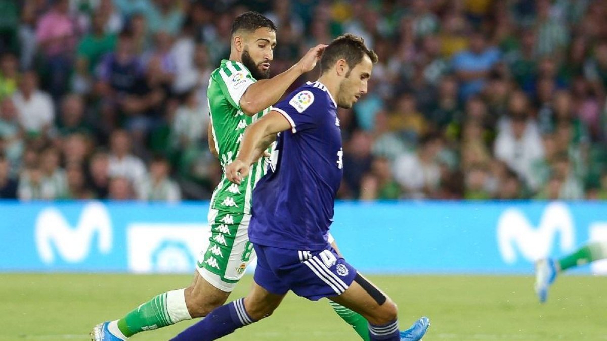 Kiko Olivas avanza con el balón ante la presencia de Fekir en el partido frente al Betis.-AFP