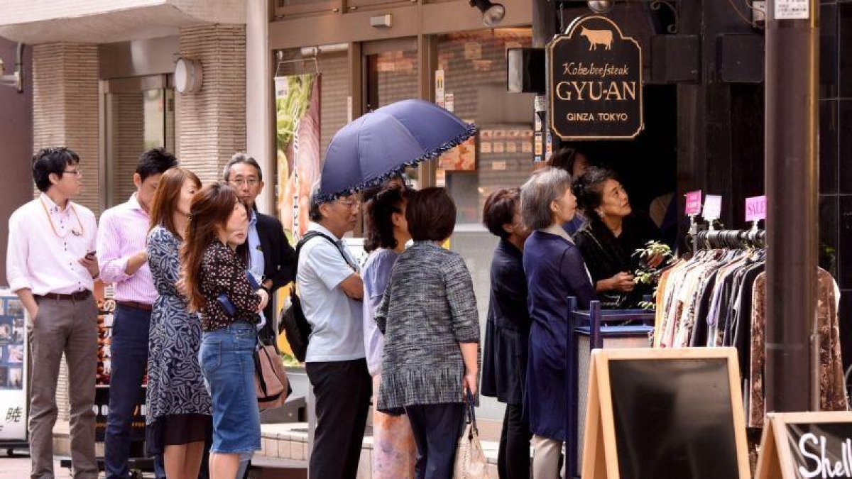 Un grupo de japoneses espera para entrar a un restaurante en Tokyo.-TORU YAMANAKA / AFP