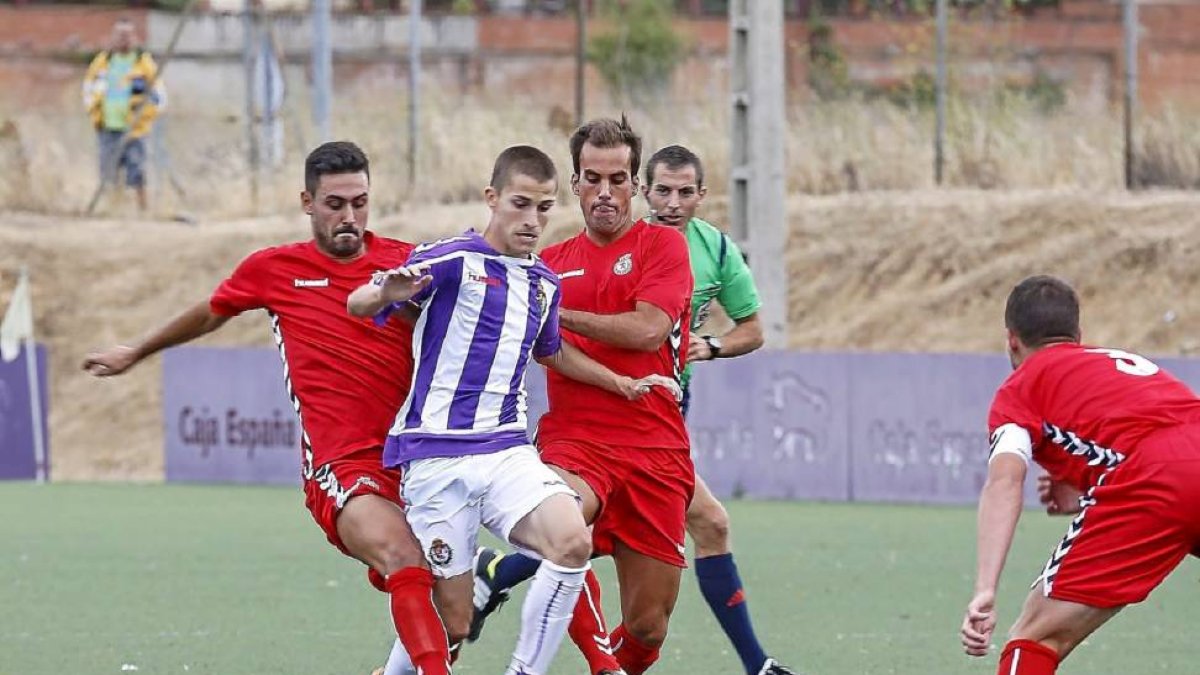 Toni, el mejor del Real Valladolid B, se zafa de la marca de dos rivales de la Cultural Leonesa.-Miguel Ángel Santos