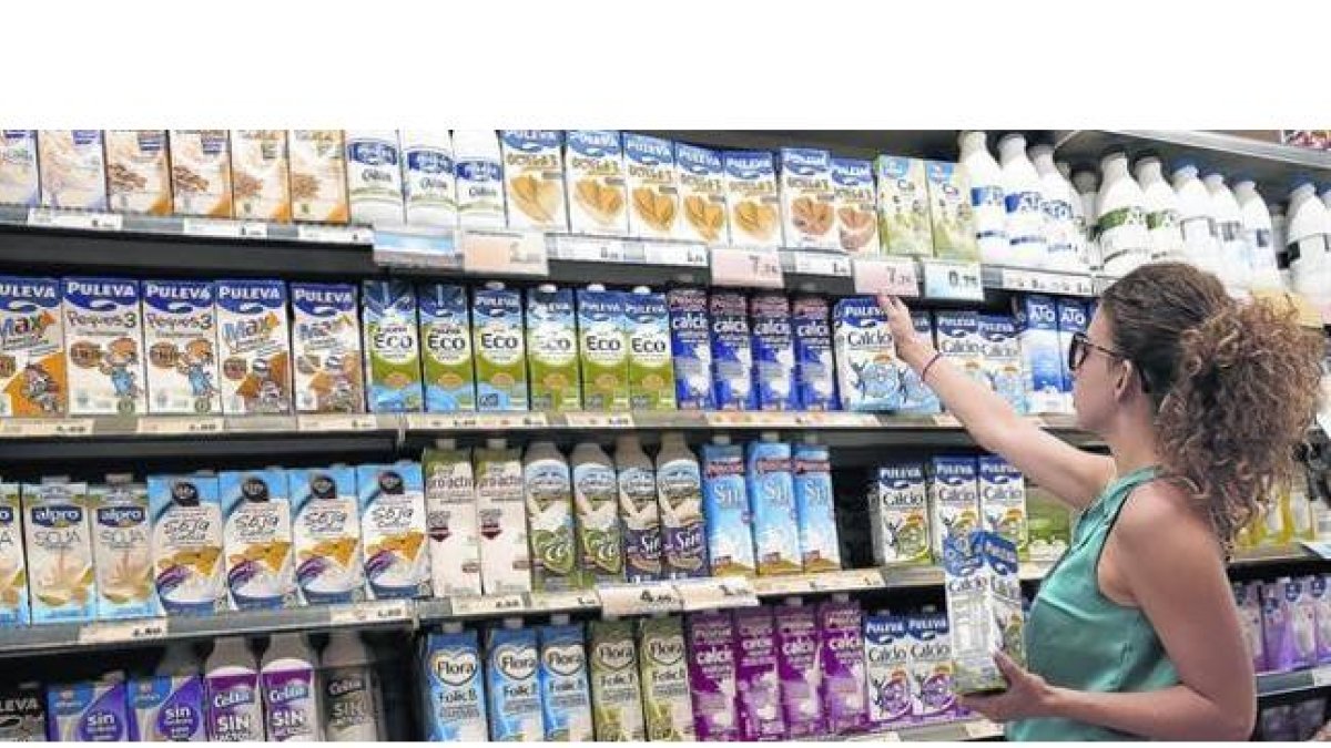 Una clienta elige leche entre la gran variedad de oferta del supermercado.-RICARD CUGAT