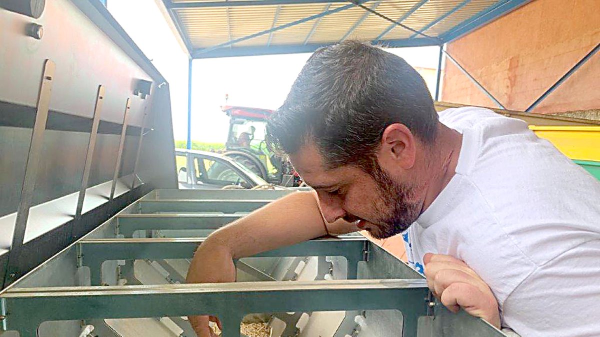 Un participante del último programa ‘Cultiva’ manipula una tolva de pienso en una granja modelo. UNIÓN DE UNIONES