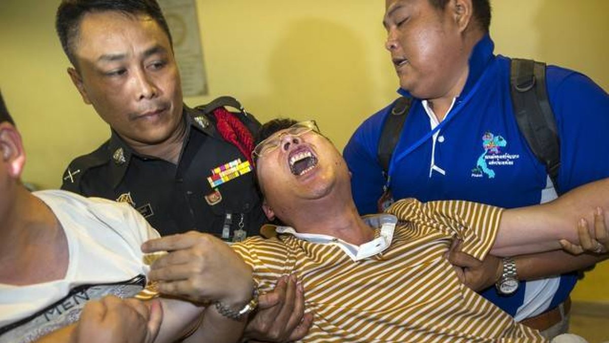 Un ciudadano chino que perdió a su mujer y a su hija en el atentado llora desconsolado en el Instituto de Medicina Forense de Bangkok.-Foto:   REUTERS / ATHIT PERAWONGMETHA