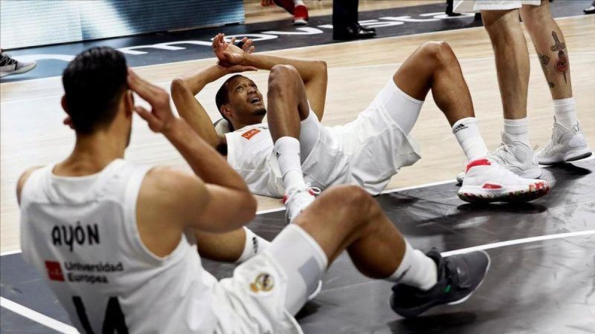 Los jugadores del Madrid, abatidos en el suelo tras la derrota.-MARISCAL (EFE)