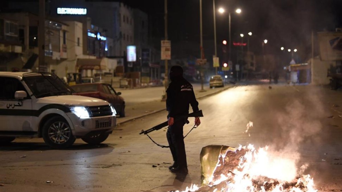 Las fuerzas de seguridad buscan en Ettadhamen, en la periferia de Túnez, a algunos participantes en las protestas, en la noche del miércoles.-/ AFP / FETHI BELAID (AFP)