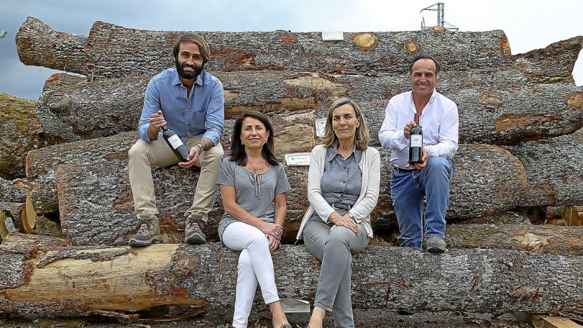 Tomás Postigo (derecha) y su hijo Gabriel, con las investigadoras Maribrí Fernández y Estrella Cadahía, sobre una pila de troncos de roble rebollo.-ARGI