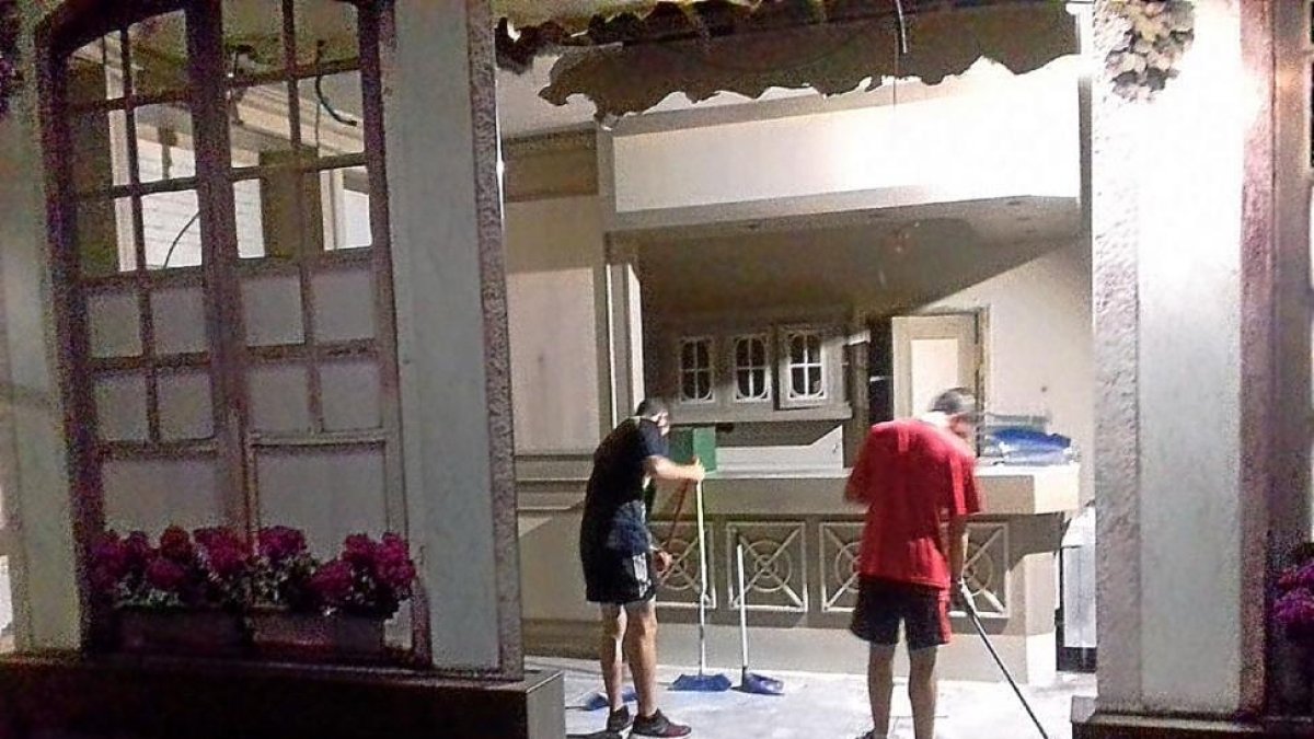 Dos miembros de La Molinera limpian el interior del hotel.-TWITTER