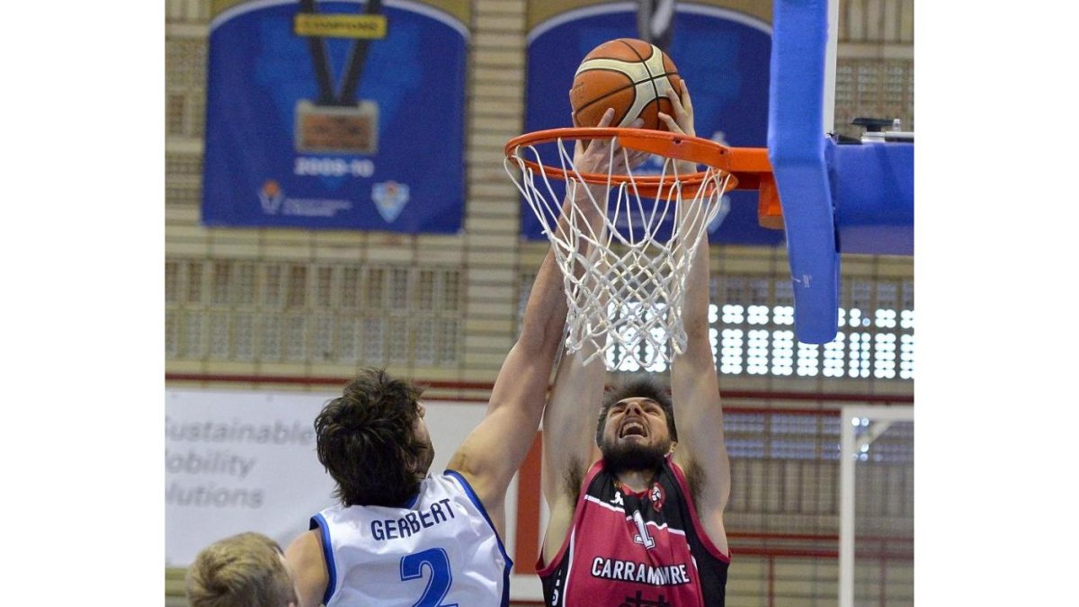 El jugador de Prat Gerbert Martí tapona un intento de machaque de Cristian Uta, ayer en el Prat-Carramimbre .-PHOTO-DEPORTE
