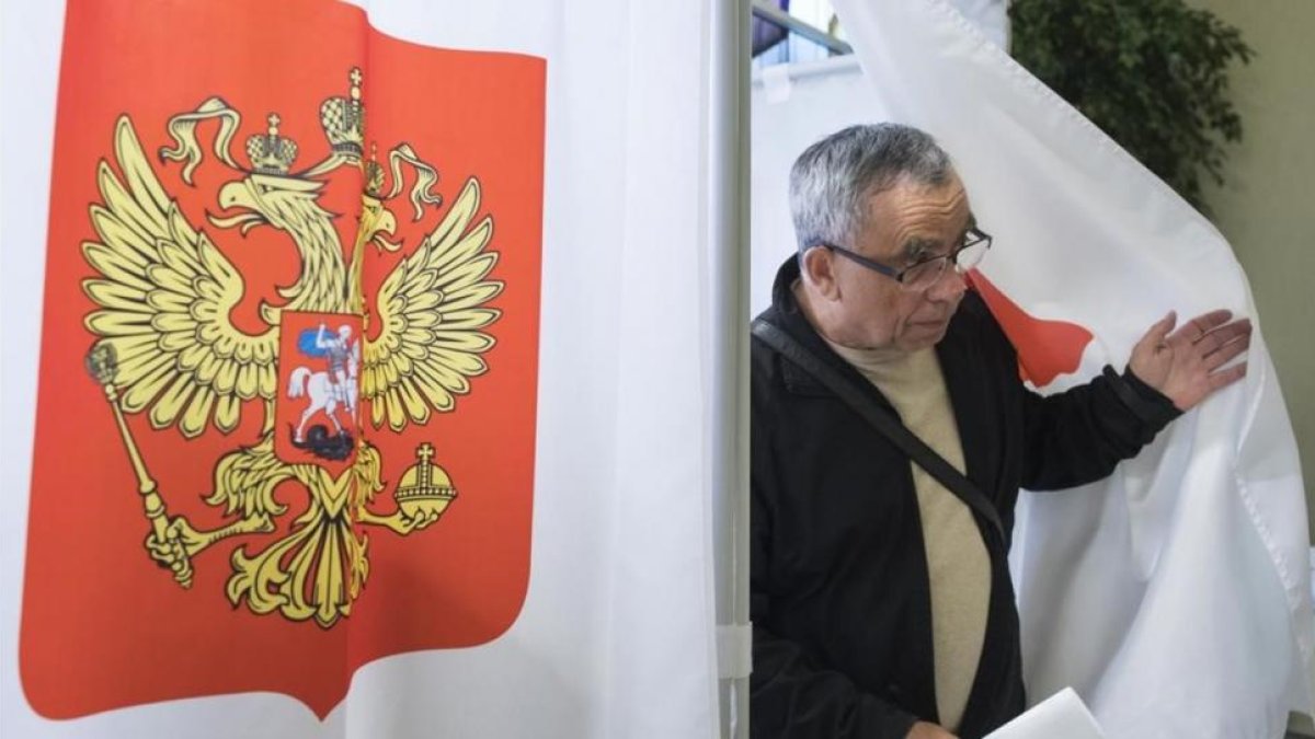 Un hombre sale de un centro de votación para las elecciones parlamentarias rusas, en la embajada de Rusia en Vilna, este domingo.-AP / MINDAUGAS KULBIS