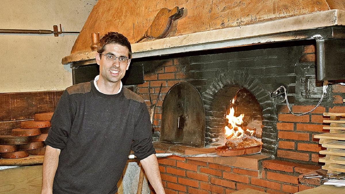Pedro Martín, cuarta generación, junto a la boca del horno de asar del establecimiento segoviano.-ARGICOMUNICACIÓN