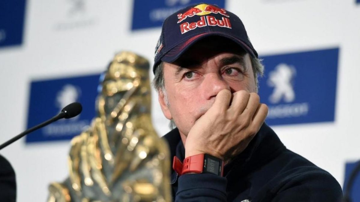 Carlos Sainz, pensativo, escucha una pregunta a su llegada a Madrid, con el trofeo de ganador del Dakar.-/ EFE / FERNANDO VILLAR