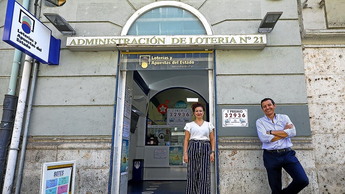 Los encargados de la Administración número 21 con el número ganador del primer premio de la Lotería Nacional.-JOSÉ C. CASTILLO / PHOTOGENIC