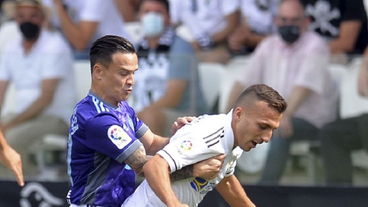 Roque Mesa disputa el balón con un rival durante el primer tiempo en El Plantío.- EM