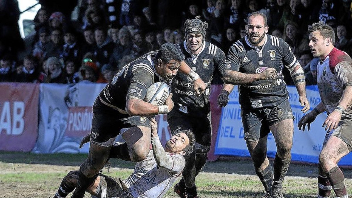 Un jugador del Alcobendas intenta placar al ‘chamizo’ Joe Mamea el pasado domingo en el embarrado Las Terrazas.-J. L. USEROS