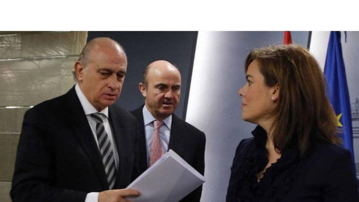 Jorge Fernández Díaz, Luis de Guindos y Soraya Saenz de Santamaría en una foto de archivo.-
