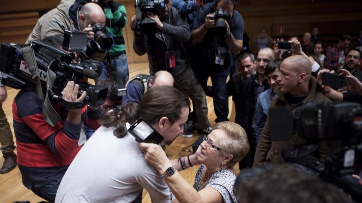 El candidato de Podemos Pablo Iglesias escucha a una simpatizante ante la nube de fotógrafos, antes de comenzar el acto en el Miguel Delibes.-J. M. Lostau
