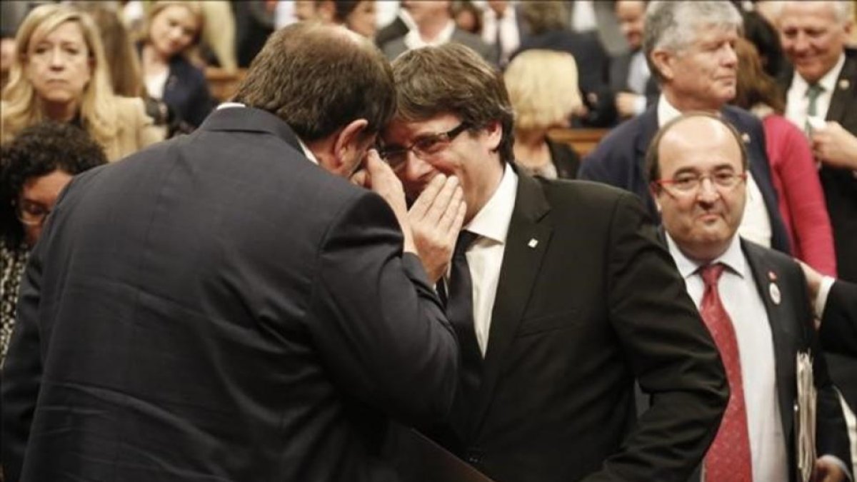 Carles Puigdemont y Oriol Junqueras conversan en el hemiciclo del Parlament.-JULIO CARBO