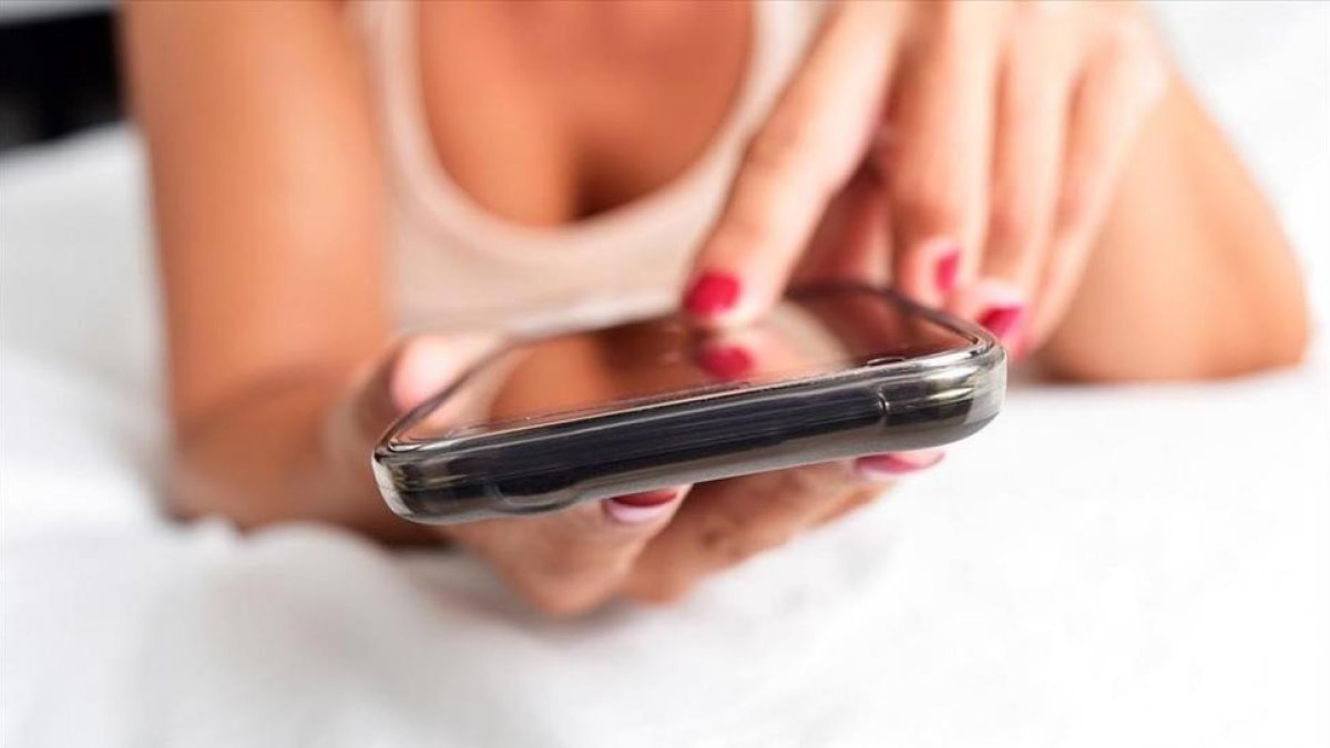 Una mujer escribiendo un mensaje con un móvil-ARCHIVO