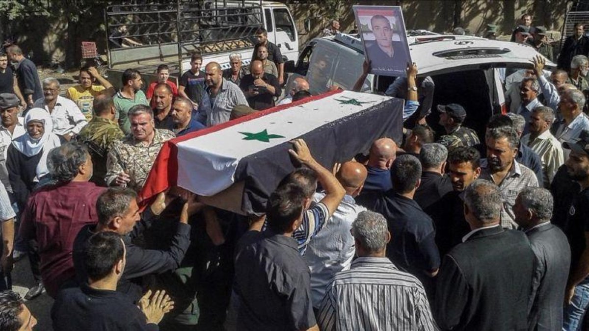 Ciudadanos sirios asisten a un funeral popular por las victimas del atentado del 25 de julio en la provincia de Al Sueida.-SANA